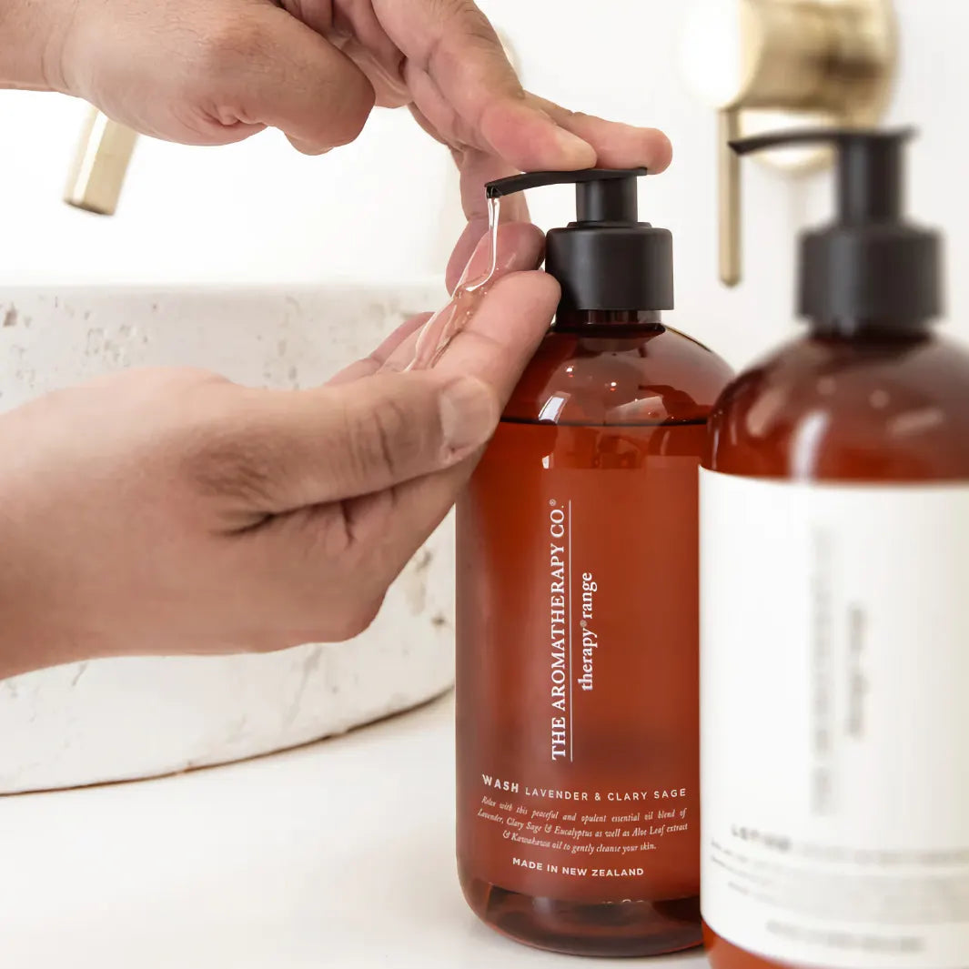 Händer pumpar ut The Aromatherapy Co Wash Lavender & Clary Sage vid handfat