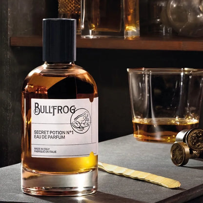 Bullfrog Secret Potion N°1 EdP parfymflaska – stämningsfull bild med glas och whisky som framhäver doftens inspiration från lönnkrogar.