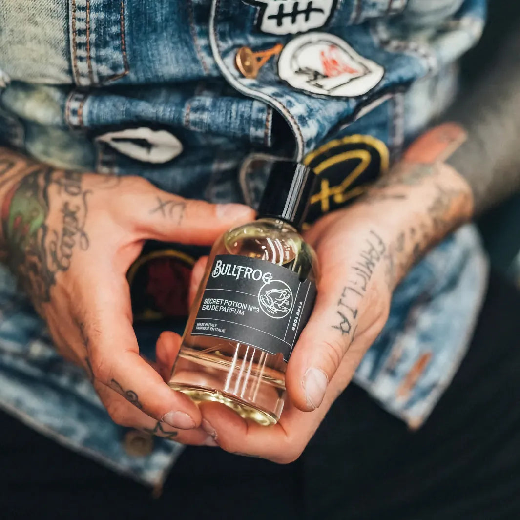 Bullfrog Secret Potion N°3 EdP i handen på tatuerad man – en djärv parfym för män inspirerad av motorcykelkultur.