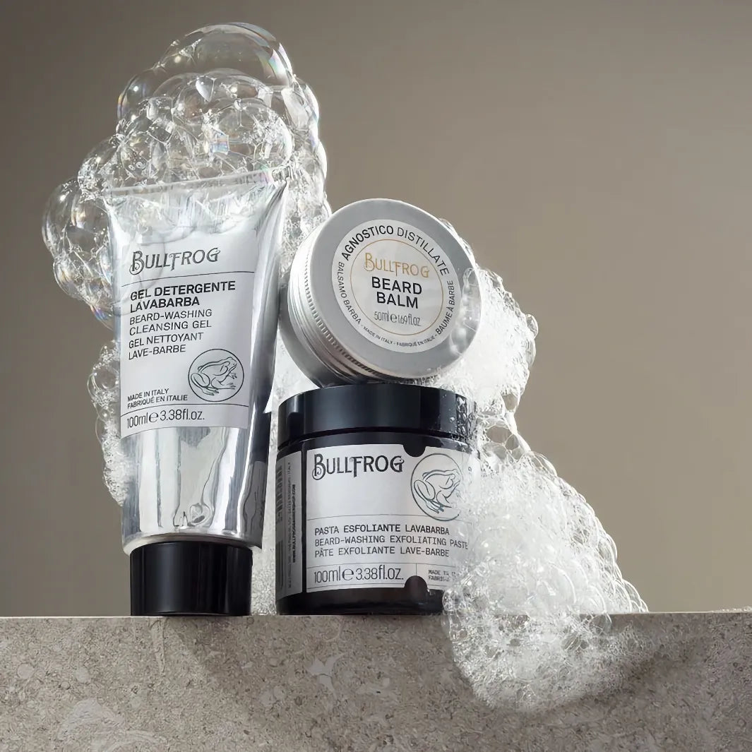 Bullfrog Beard-Washing Exfoliating Paste 100 ml tillsammans med Bullfrog Beard Balm och Cleansing Gel, omgiven av lödder.