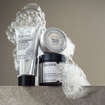 Bullfrog Beard-Washing Exfoliating Paste 100 ml tillsammans med Bullfrog Beard Balm och Cleansing Gel, omgiven av lödder.