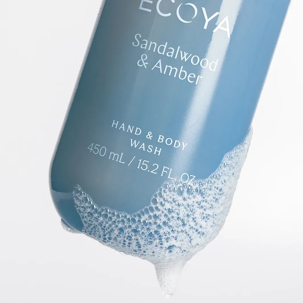 Ecoya Sandalwood & Amber Hand & Body Wash 450 ml med rengörande tvållödder på den blå flaskan