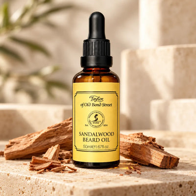 Taylor of Old Bond Street Sandalwood Beard Oil 50 ml med varm träig doft, fotograferad med sandelträ på ljus sten.