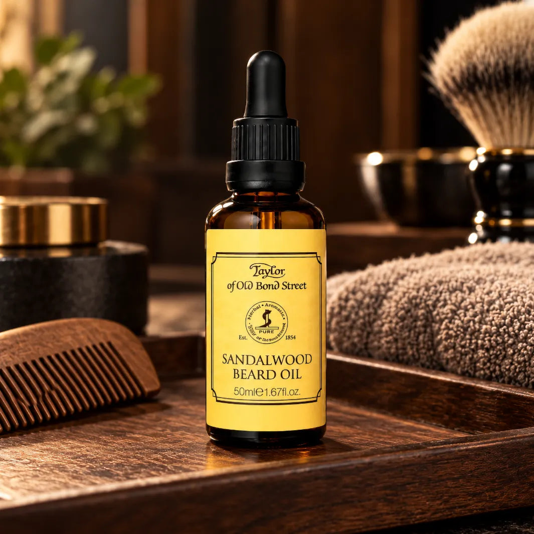 Taylor of Old Bond Street Sandalwood Beard Oil 50 ml på träbricka med skäggkam, handduk och rakborste.