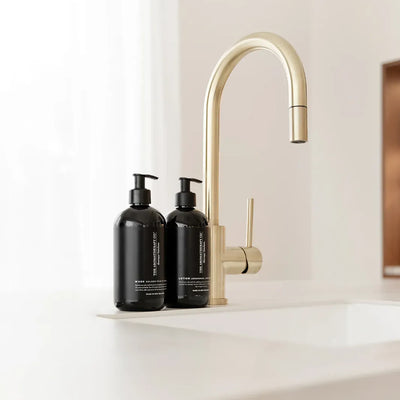 The Aromatherapy Co Therapy Kitchen handtvål och handlotion bredvid mässingsblandare