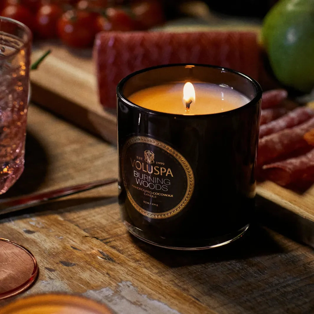 Voluspa Classic Maison Burning Woods doftljus 270 g tänt på träbord i varm och ombonad miljö